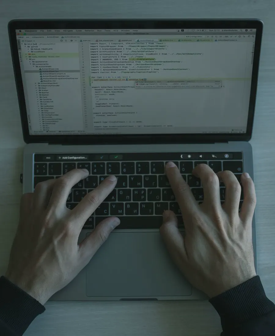 Hands typing code on a laptop keyboard